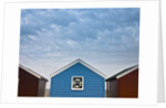 Beach huts in a row against sky by Assaf Frank